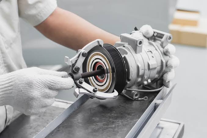 Mechanic removing AC compressor pulley