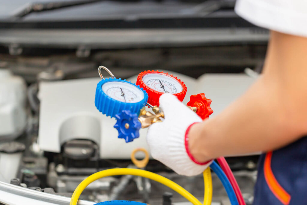 Technician using car AC manifold gauge