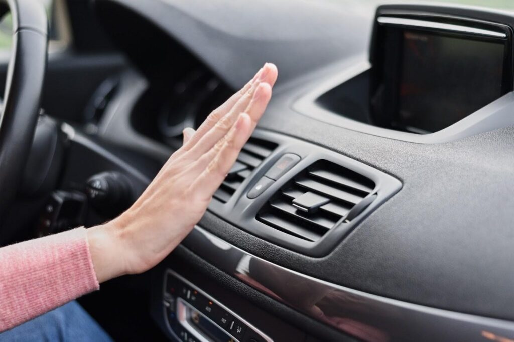 Hand in front of car AC vent