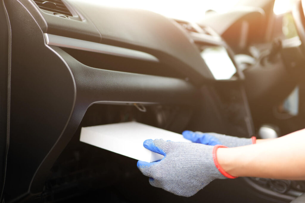 Technician installing car cabin air filter