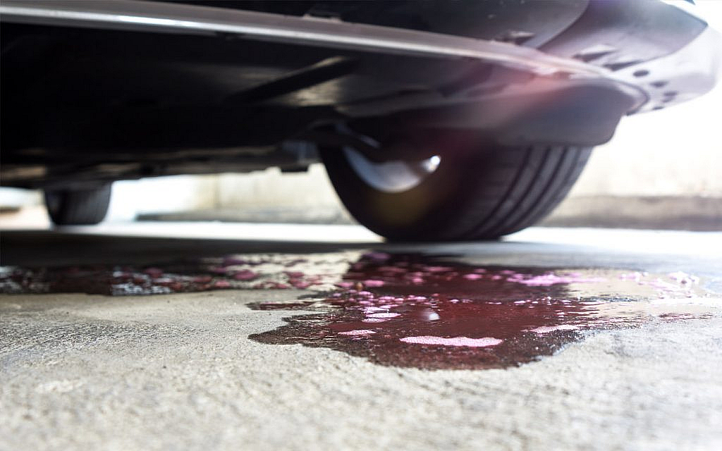 Purple liquid leaking from underneath a parked car